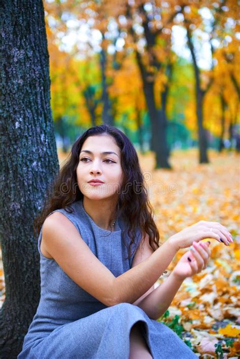 Woman Posing With Autumn Leaves In City Park Outdoor Portrait Stock