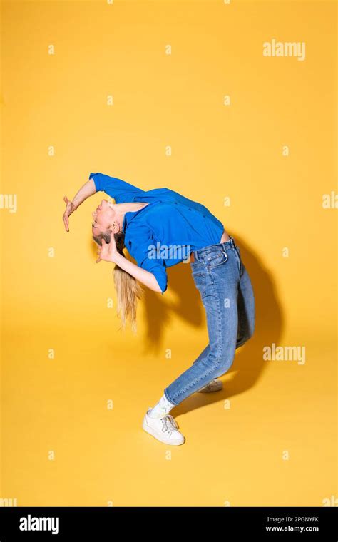 Woman Bending Over Backwards Against Yellow Background Stock Photo Alamy