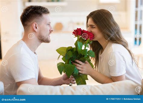 handsome man surprising his beautiful wife with roses on saint valentine`s day happy romantic