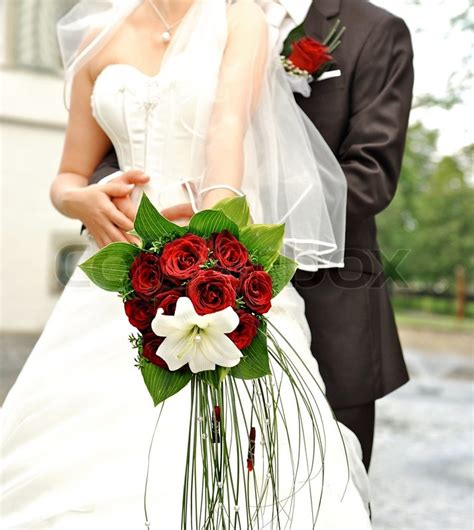 Wedding traditions and customs vary greatly between cultures, ethnic groups, religions, countries, and social classes. Bride holding beautiful red roses. ... | Stock image ...