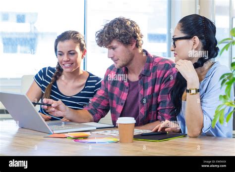 Smiling Partners Working Together With Photographs Stock Photo Alamy
