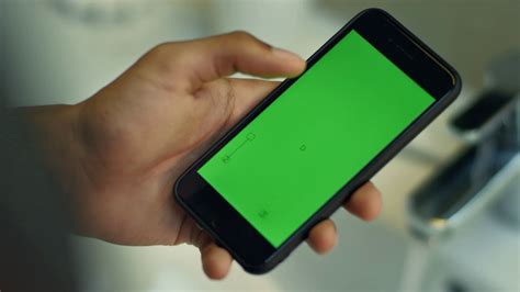 Man touching smartphone with chroma key green screen. Close up of smart phone with green screen in male hand. Mobile phone with green screen in ...