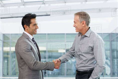 Two Businessmen Shaking Hands In Office Stock Photo Dissolve