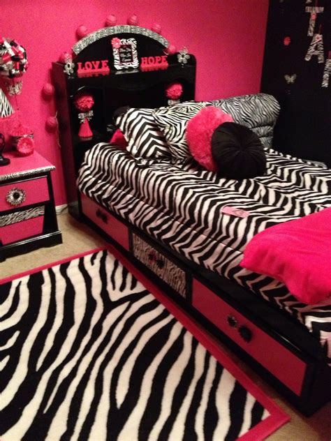 A Zebra Print Bedroom With Pink Walls And Black Bedding Rugs And Drawers