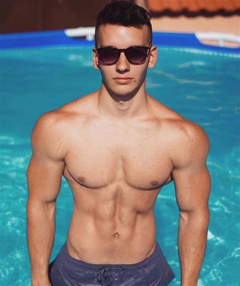 a man standing in the water with his hands on his hips and wearing swim trunks