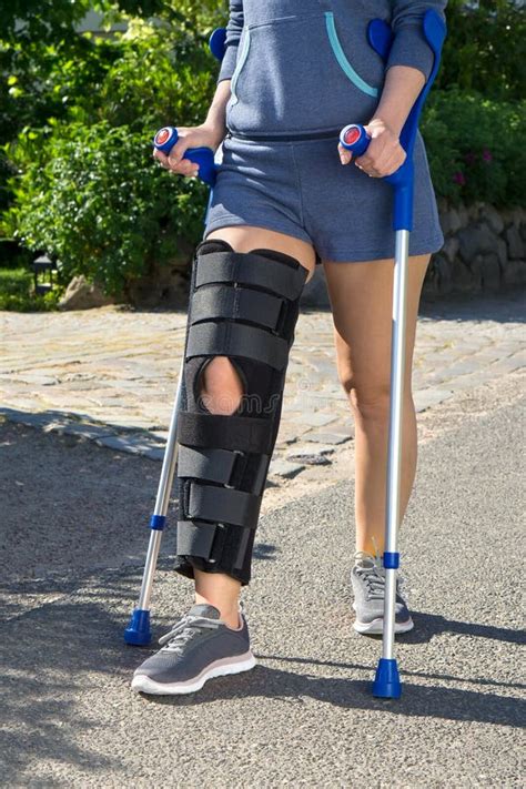 Woman Wearing A Leg Brace Walking On Crutches Stock Photo Image Of