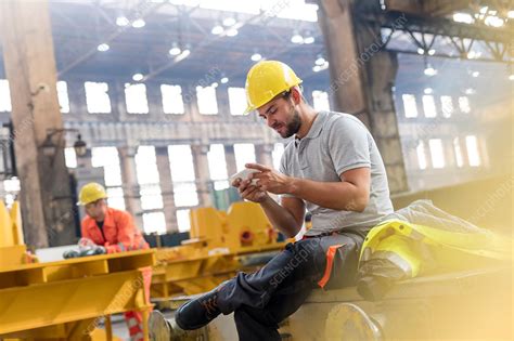 Steel Worker Texting Taking A Break In Factory Stock Image F017