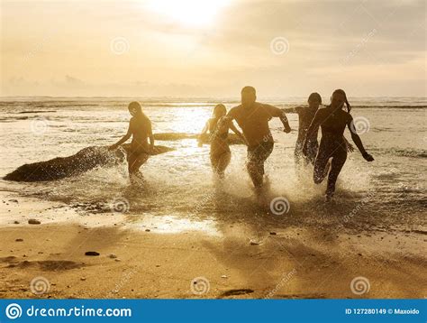 Silhouettes Of Friends Running Out Of The Ocean Stock Image Image Of