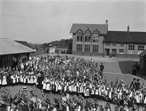 Hun og datteren mille er på vei nedover gågata for å møte familien. 17. mai i skolegården ved en Havnaberg skole. Barn står i ...
