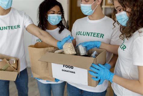 Voluntarios Empacando Donaciones De Comida Hombre Dando Caja De Cartón