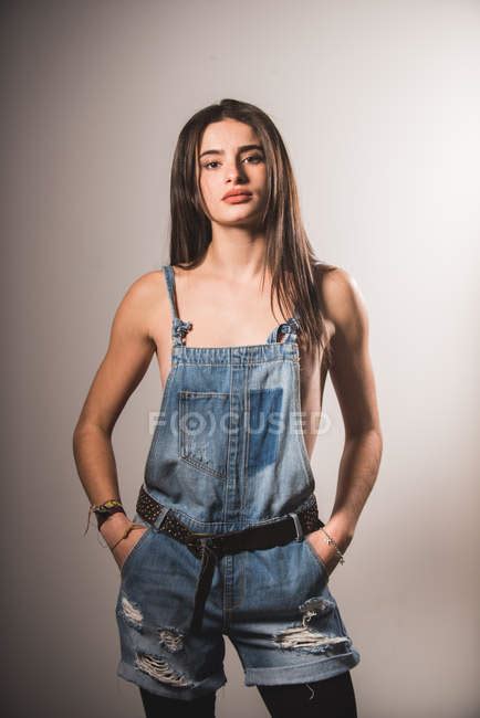 Front View Of Brunette Topless Girl Posing In Denim Overall And Looking At Camera Sensuality