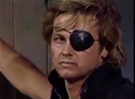 A Man With Black Eye Patches On His Face Pointing At Something In Front