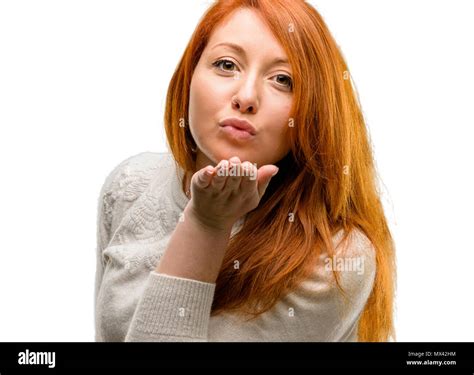 Beautiful Young Redhead Woman Expressing Love Blows Kiss At Camera Flirting Isolated Over