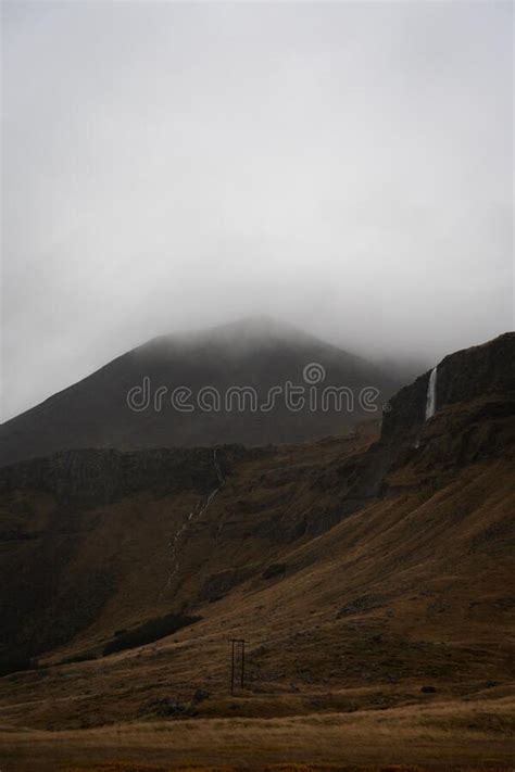 Foggy Mountain Top With Autumn Colors And Waterfall In Iceland Stock