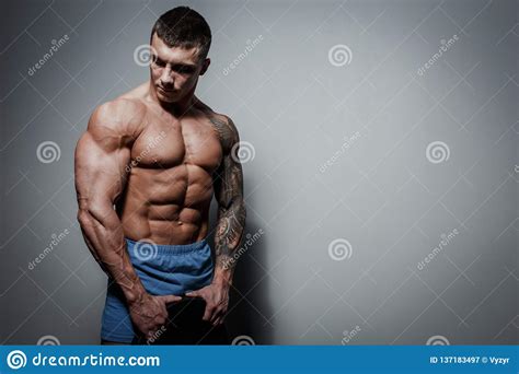 Athletic Pumped Man Athlete Bodybuilder With Great Muscled Body On Gray Background Stock Image