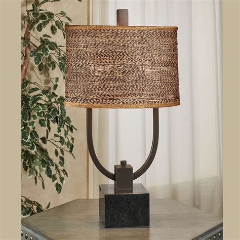 This contemporary iron base showcases clean lines that are finished in a plated brushed nickel that is accented by a thick crystal foot. Carolyn Kinder Stabina Table Lamp with Woven Rattan Shade