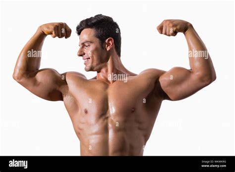 Portrait Of A Muscular Young Man Flexing Muscles Over White Background
