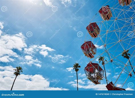 Colorful Ferris Wheel Against A Vibrant Blue Sky And Palm Trees With