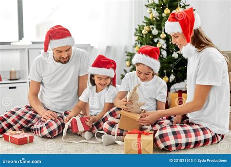 Feliz Familia Abriendo Regalos De Navidad En Casa Imagen De Archivo