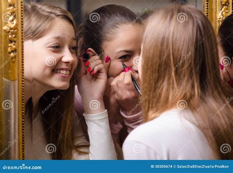 A Colocação Bonita Das Meninas Compo Na Frente Do Espelho Imagens De