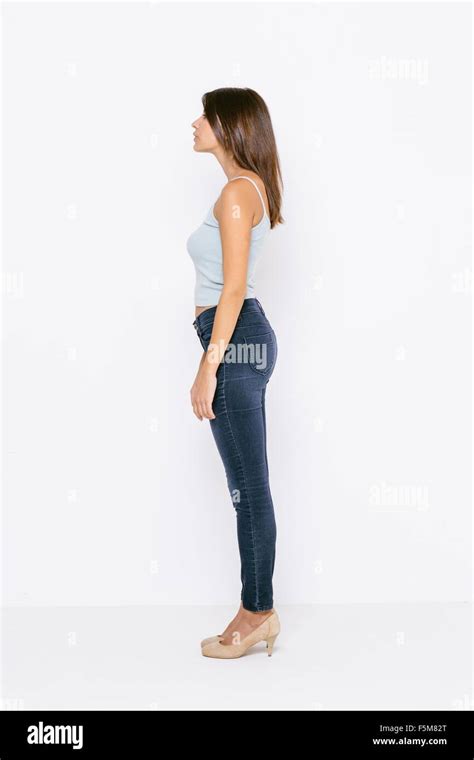 Full Length Side View Of Young Woman Wearing Vest And Skinny Jeans