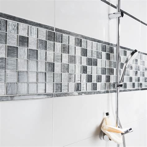 Carrelage, parquet, moquette ou lino. Un carrelage mural blanc avec de la mosaïque grise et ...