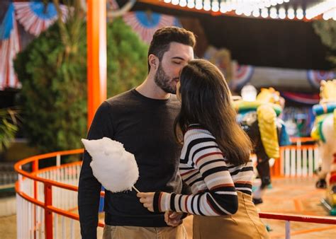 Pareja Besándose En El Parque De Atracciones Foto Gratis