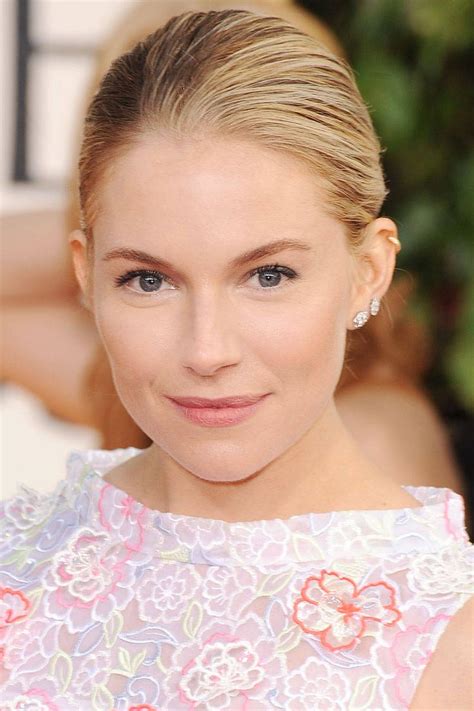 A Woman With Blonde Hair And Blue Eyes Wearing A Pink Floral Dress At