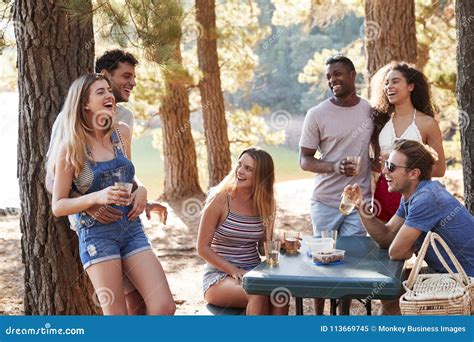 Group Of Adult Friends Hanging Out By A Lake Close Up Stock Image Image Of Communication
