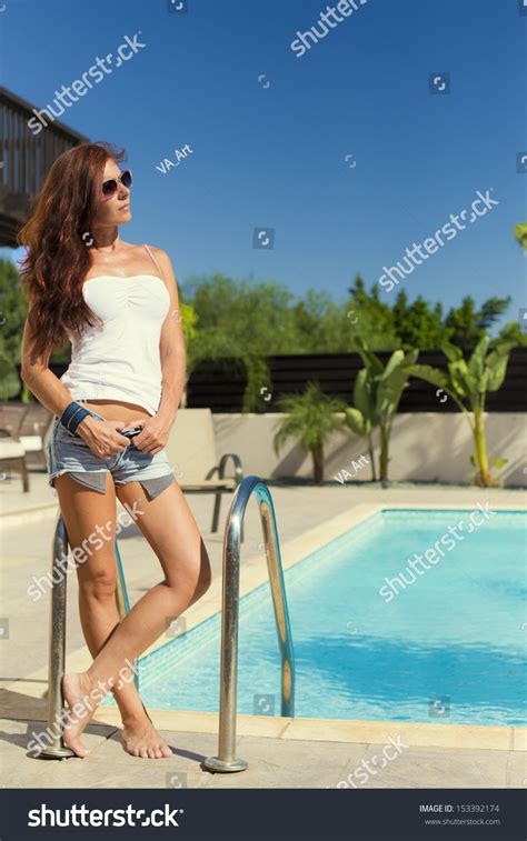 Beautiful Model In Sunglasses Posing Near The Pool Stock Photo