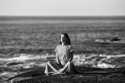 Yoga Woman Meditating On Rocks Ocean Beach In Calm Weather Black And