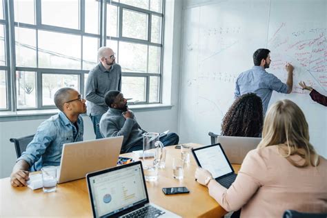 Business People Using Whiteboard In Meeting Stock Photo