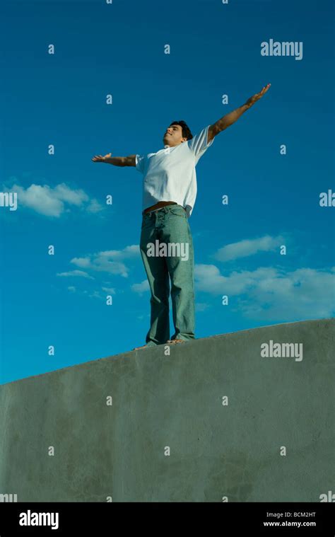 Man Standing On Ledge With Arms Outstretched Stock Photo Alamy