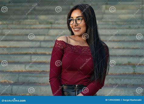 A Beautiful Girl Of Eastern Ethnicity Turkmen In Glasses Is Resting In A Cafe On The Couch
