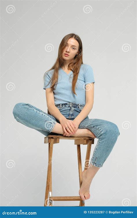 Young Woman Is Sitting On Wooden Chair In Studio Stock Image Image Of