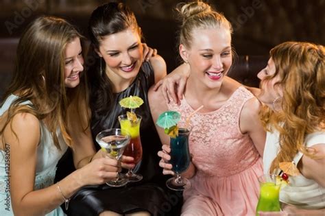 Female Friends Interacting With Each Other While Having Cocktail Buy