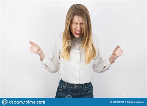 Young Beatuiful Blond Angry Woman Looks Furious Clenching Her Fists
