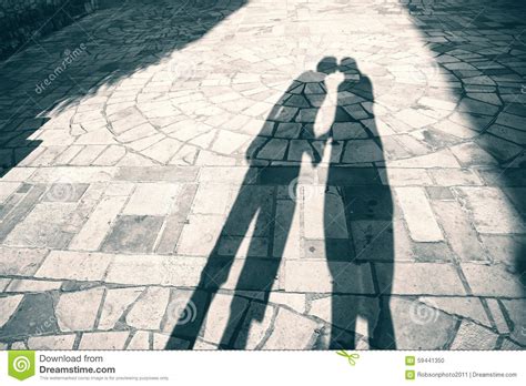 Silhouette Shadow Of Two People Holding Hands And Kissing