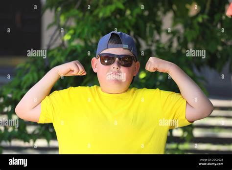 Fat Boy In A Yellow T Shirt And Sunglasses Shows Muscles High Quality