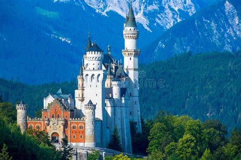 Palace Neuschwanstein Surrounded By Wooded Mountains Stock Photo