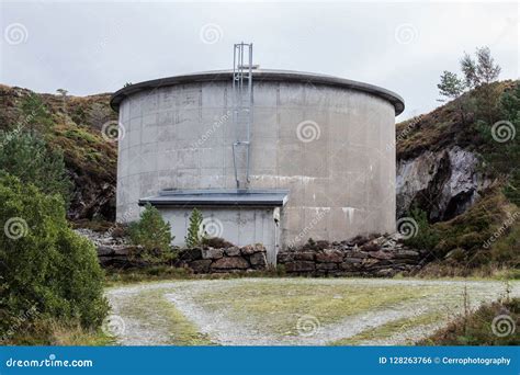 Old Rustic Water Tower With Gloomy Overcast Background Stock Photo