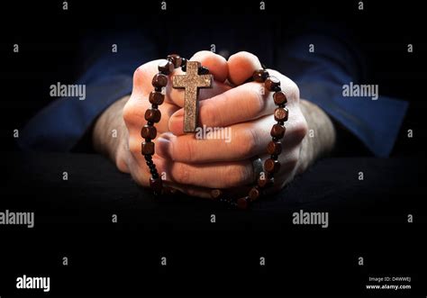 Hands Holding Rosary Beads And Cross While Praying Stock Photo Alamy