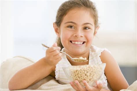 Young Girl Eating Cereal In Living Room Smiling Stock Photo Image Of