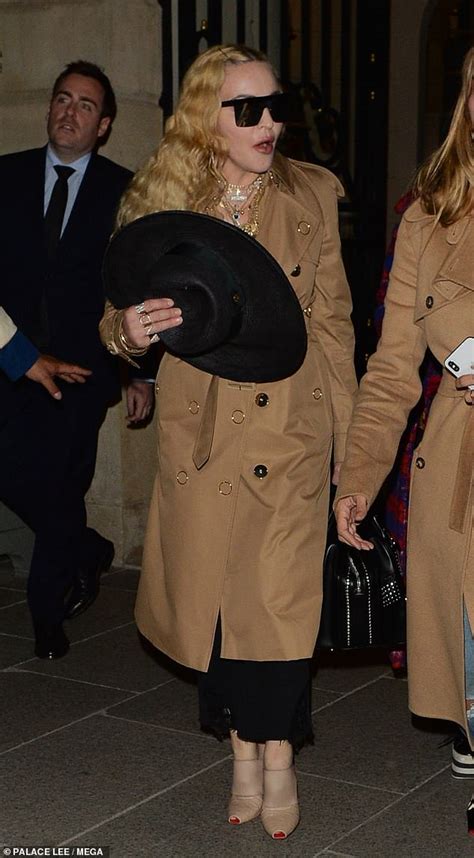 madonna looks shocked as she heads out in a trench coat and sunglasses during paris fashion week