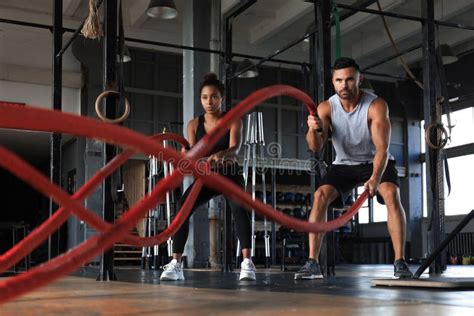 Athletic Young Couple With Battle Rope Doing Exercise In Functional