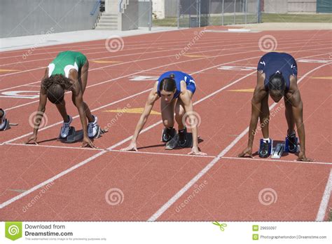 Female Athletes At Starting Line On Race Track Royalty Free Stock ...