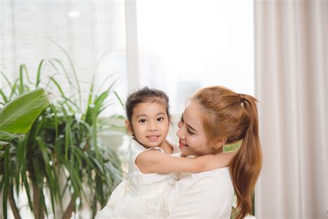 Bahagia Ibu Asia Memeluk Dengan Putri Kecilnya Yang Lucu Di Rumah Foto