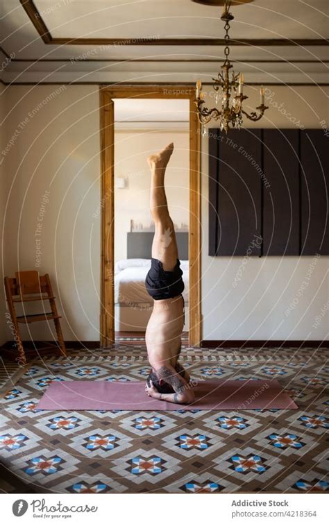 Man Doing Yoga In Supported Headstand Pose At Home A Royalty Free
