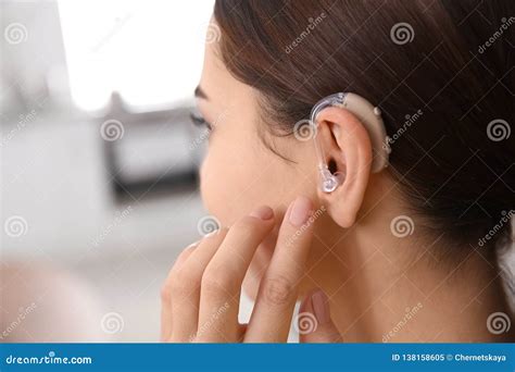 Young Woman Adjusting Hearing Aid Indoors Stock Image Image Of