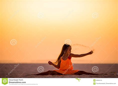 Silhouette Of Sporty Little Girl On White Beach At Sunset Stock Photo
